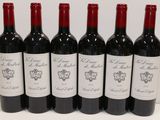 six bottles of red wine are lined up on a table