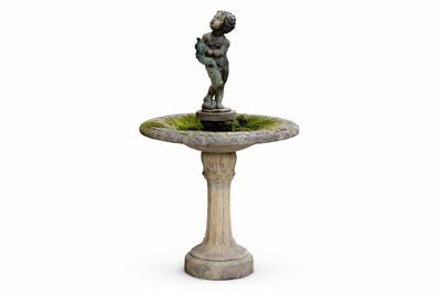 une petite statue représentant un garçon tenant un oiseau, posée sur un socle