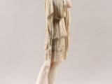 an antique statue of a woman in a dress holding a purse
