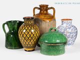 de nombreux vases de différentes couleurs posés sur une surface blanche