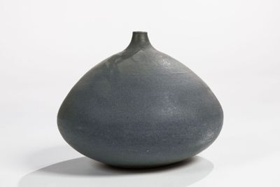 a gray vase that is sitting on a white surface