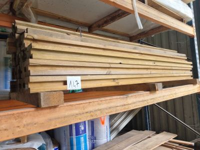 de nombreuses pièces de bois empilées sur les étagères du garage