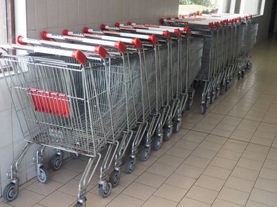 une rangée de caddies alignés contre un mur dans un magasin