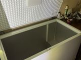 a white chest freezer sitting on a tiled floor