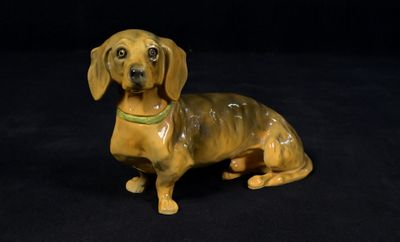 a figurine of a dachshund dog on a black background