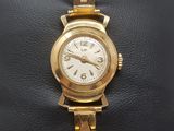 an image of a close up of a gold wrist watch on a black bag