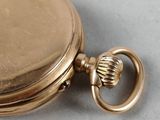 a close up of a gold pocket watch on a table