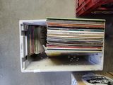 une pile de disques dans une boîte blanche posée sur une étagère