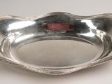 an antique silver plate with a red rose in the center