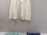 une chemise blanche, un jean bleu et un gilet blanc accrochés au mur
