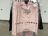 une veste et un pantalon roses suspendus à un cintre dans un magasin