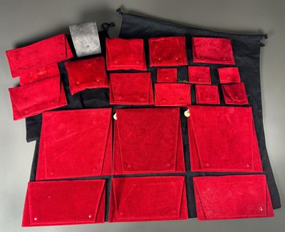 un assortiment de sacs à main en velours rouge et d'autres articles posés sur une table