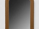 une image représentant un miroir accroché à un mur blanc, dans un cadre en bois