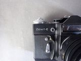 a black camera sitting on a table with a white background