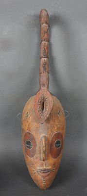 une image d'un masque en bois accroché au mur