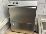 stainless steel dishwasher and sink in a kitchen with tiled walls