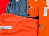 several pairs of orange, blue, and grey shorts are sitting on a table