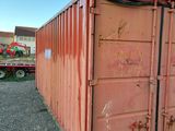 a red container that is sitting in the gravel