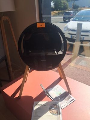 une grille noire posée sur une table devant une fenêtre