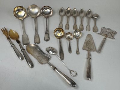 de nombreuses cuillères et couverts en argent disposés sur une table