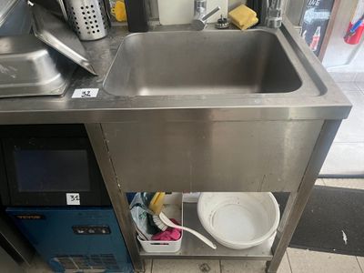 un évier en inox et un micro-ondes dans une cuisine