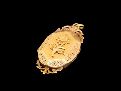 un pendentif en or orné d'une image de fleur