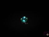 un gros plan d'un cristal vert sur une surface noire