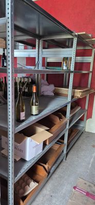 many shelves with bottles of wine on them in a room