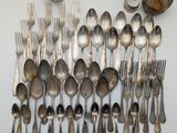 a lot of silver spoons and spoons on the table