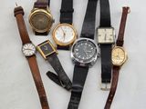 several different types of watches are arranged on a white surface