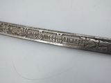 a silver spoon with writing on it sitting on a table