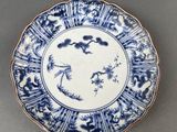 blue and white plate with birds and flowers on it on a gray surface
