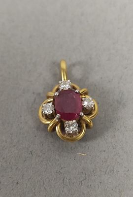 un gros plan d'un pendentif en rubis et diamants posé sur une table