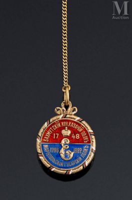a close up of a gold necklace with a medal on it
