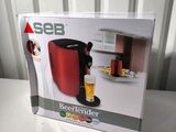 the box is open on the table with the coffee maker in it