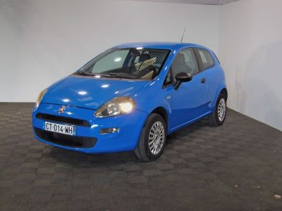 the small blue car is parked in a large room