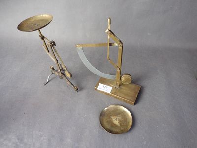 une balance et deux objets en laiton posés sur une table
