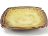 a brown plate with a brown rim on a white surface
