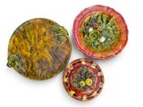 trois assiettes contenant différents types d'aliments, posées sur une surface blanche