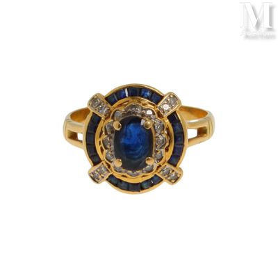 gros plan d'une bague en or avec une pierre bleue et des diamants