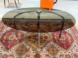 une table en verre avec un plateau en verre, posée sur un tapis dans une pièce
