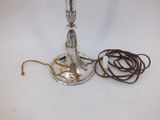 a silver candle that is next to a brown cord