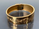 a close up of a gold bracelet on a table