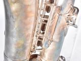 a silver saxophone that is sitting in a clear box