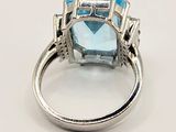 an image of a ring with a blue topazr stone and diamonds