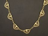 gros plan d'un collier en or sur une surface noire