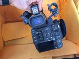 a person holding a video camera in a yellow chair