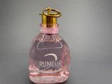pink perfume bottle with a gold top on a gray surface