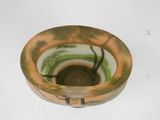 a green and brown bowl sitting on a white surface