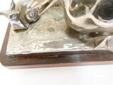 une statue en argent représentant un escargot, posée sur un socle en bois